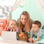 Image d'une babysitter avec 2 enfants lisant un livre