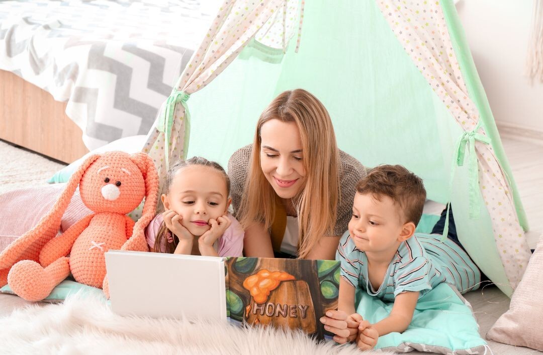 Image d'une babysitter avec 2 enfants lisant un livre